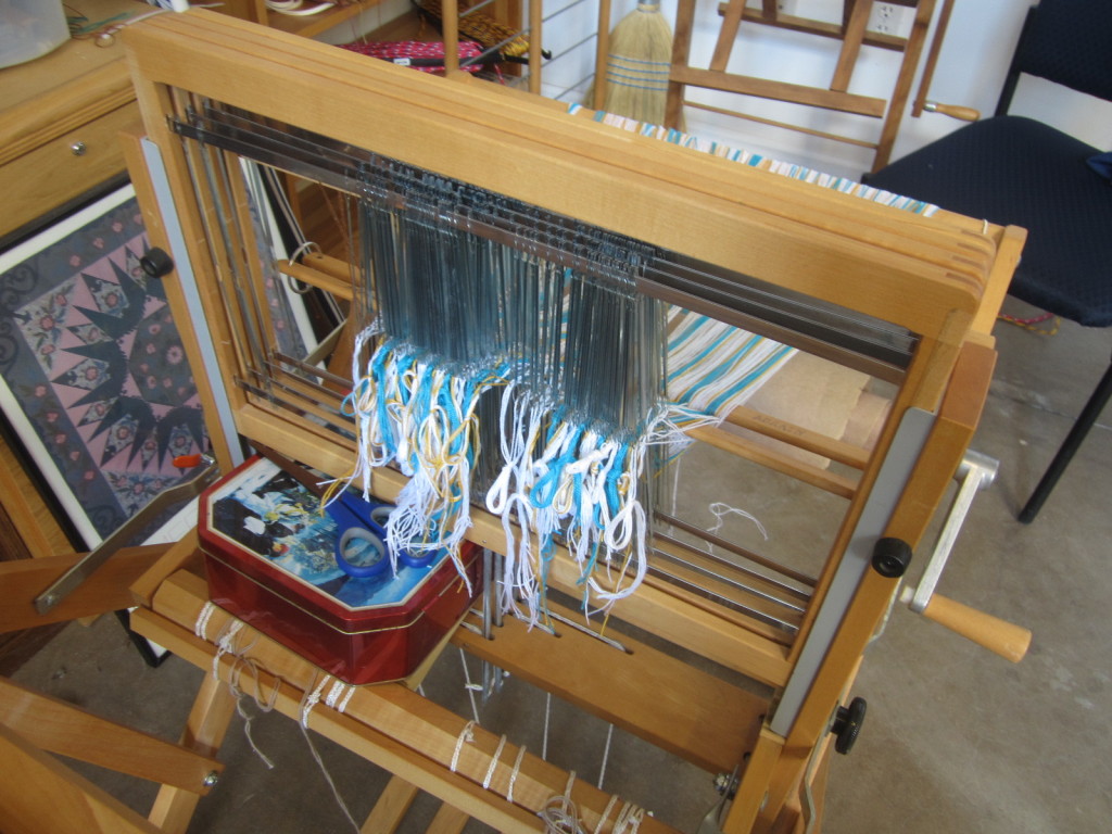 Warp fully threaded through the heddles