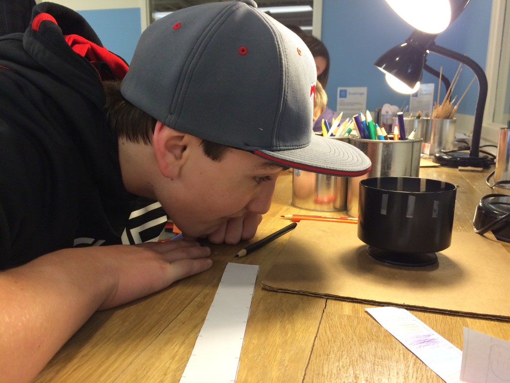 Noah checks out a zoetrope or device for making simple animation
