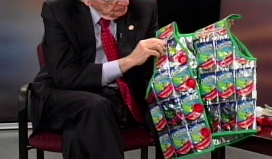 Delegate Ken Plum examines a vest made from juice pouches and plastic caps