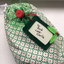 Environmentally-friendly gift wrapping - fabric bag, reusable gift tag, bow from recycled 2L bottle and cap - designed by Trashmagination