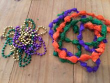 Typical Mardi Gras beads beside DIY Mardi Gras beads from plastic produce bags and table cloths - designed by Trashmagination