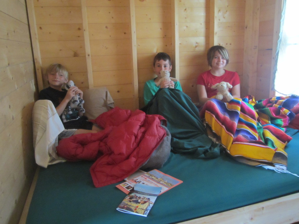 Kids playing on double bed area of treehouse