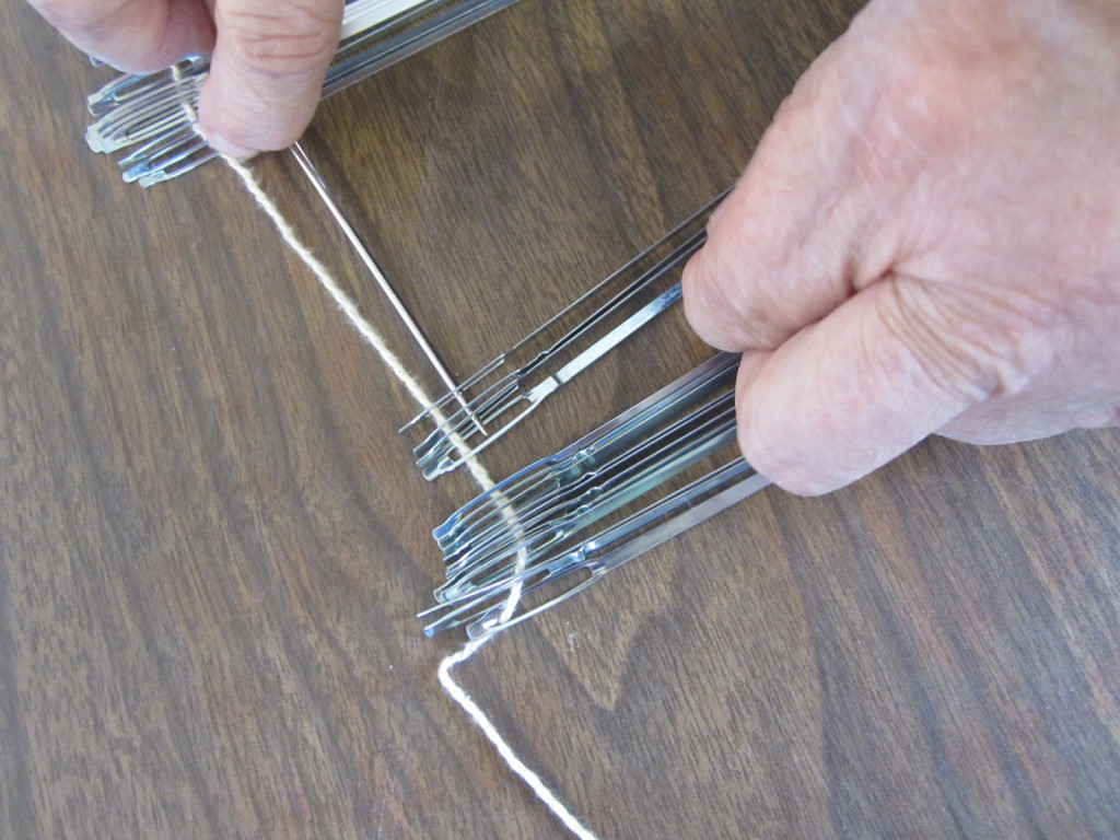 Adding heddles to a shaft - first put them on a string to keep them aligned