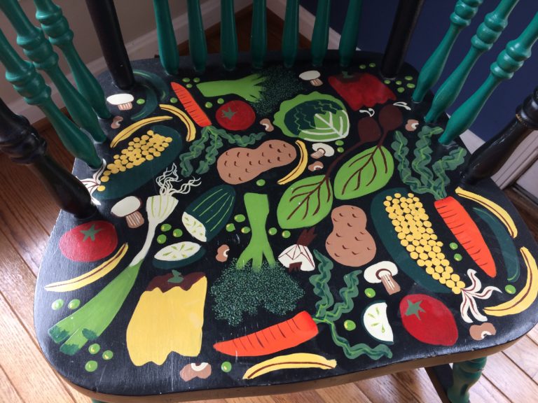 Seat of a rocking chair colorfully painted by Trashmagination - decorated with vegetables - called the Vege-chair