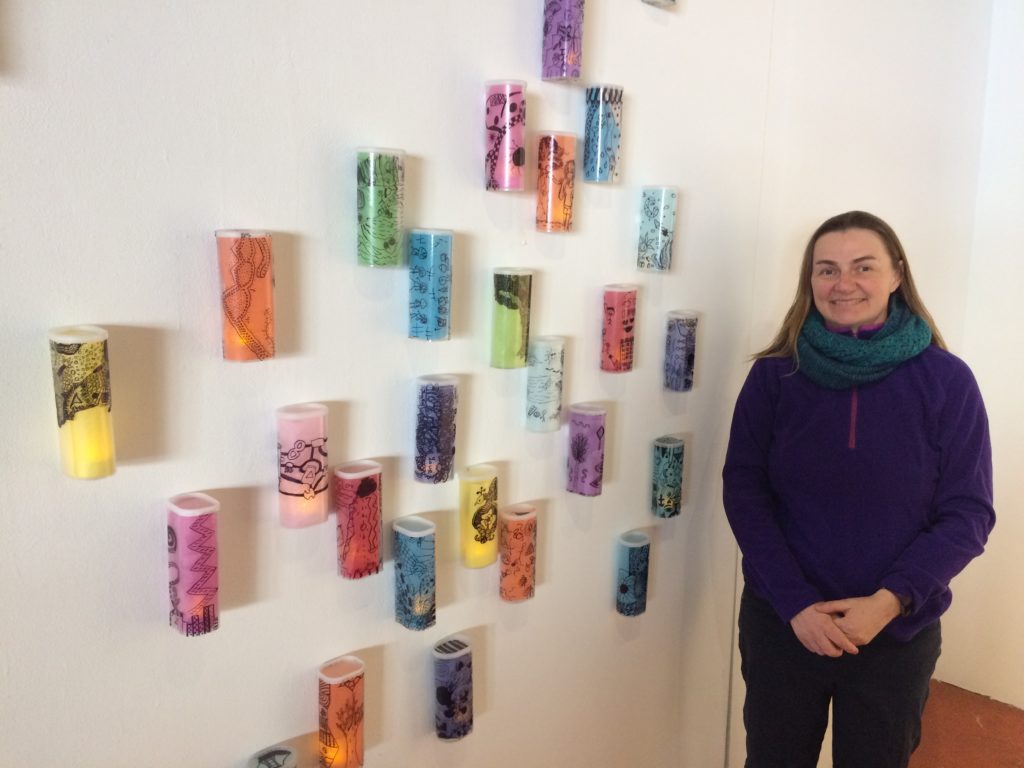 Woman standing beside "Lanterns" from recycled Crystal Light Containers and Tissue Paper Inspired by Paul Klee - designed by Trashmagination
