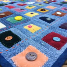 Denim quilt sewn with patches of velvet and decorative buttons