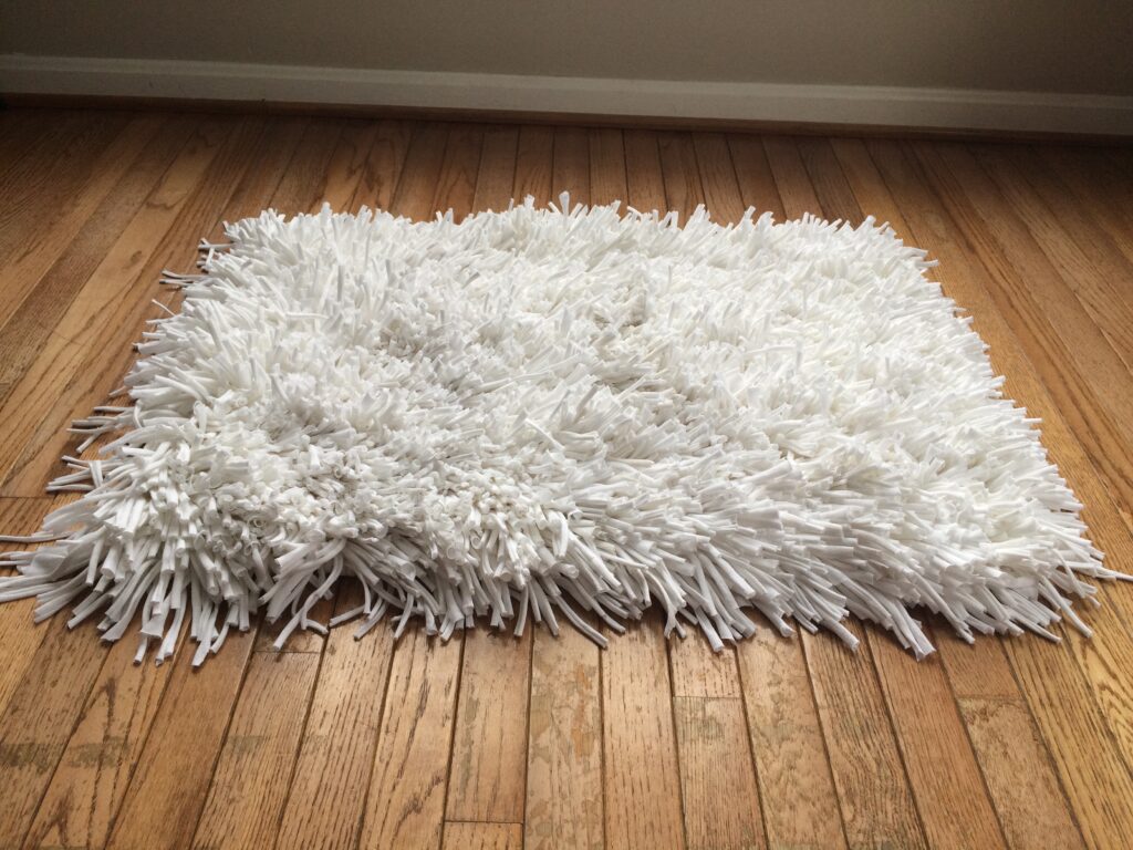 White fluffy rug woven by Trashmagination from recycled t-shirts