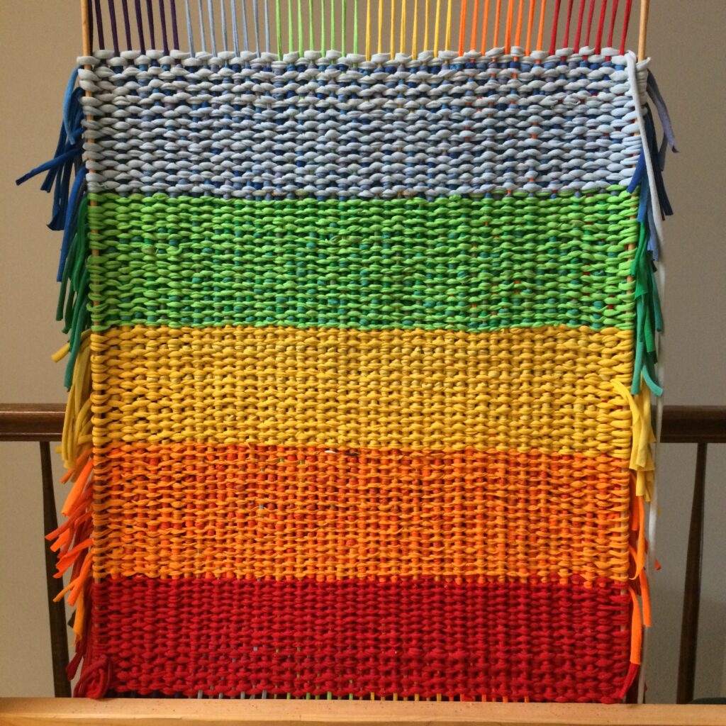 Back of the rainbow rug woven by Trashmagination