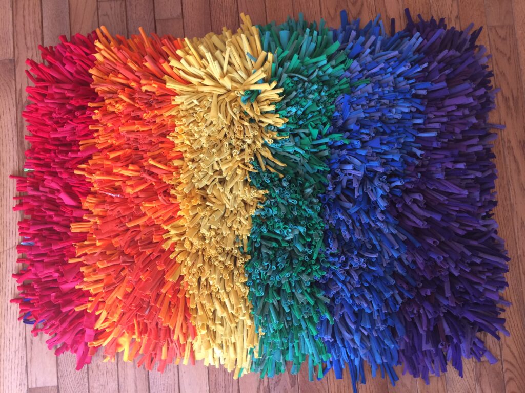 Rainbow rug woven by Trashmagination made from recycled t-shirts